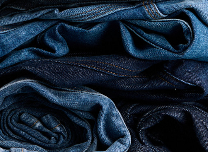 Stack of DUER blue jeans with various shades