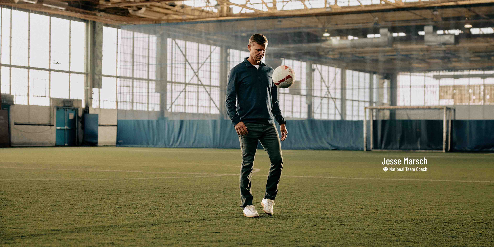 Man holding a soccer ball on an indoor sports field with 'Jesse Marsch' text overlay