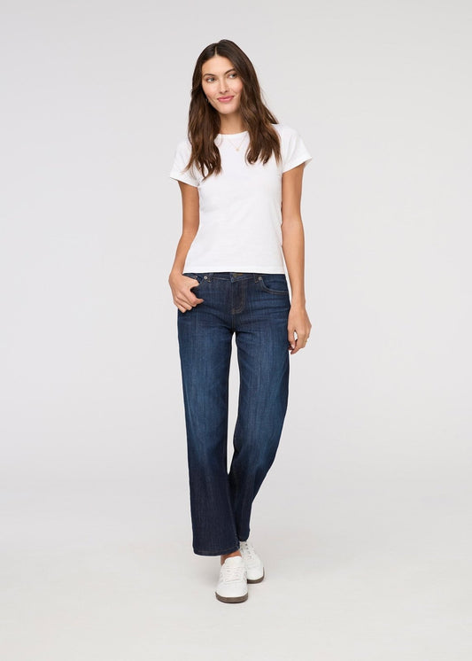 Woman wearing a white t-shirt and blue jeans on a white background