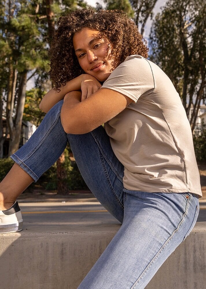 womens light blue mid rise relaxed stretch jeans sitting outside